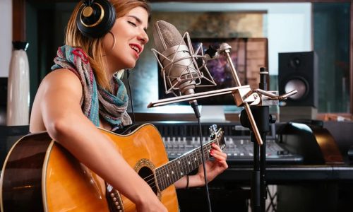 Independent musician calculating expenses to budget and finance their music career successfully.