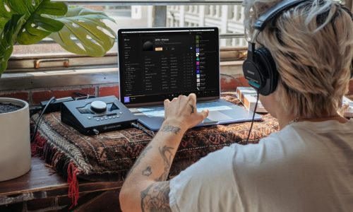 Artist comparing EP and single release formats on a laptop with music notes.
